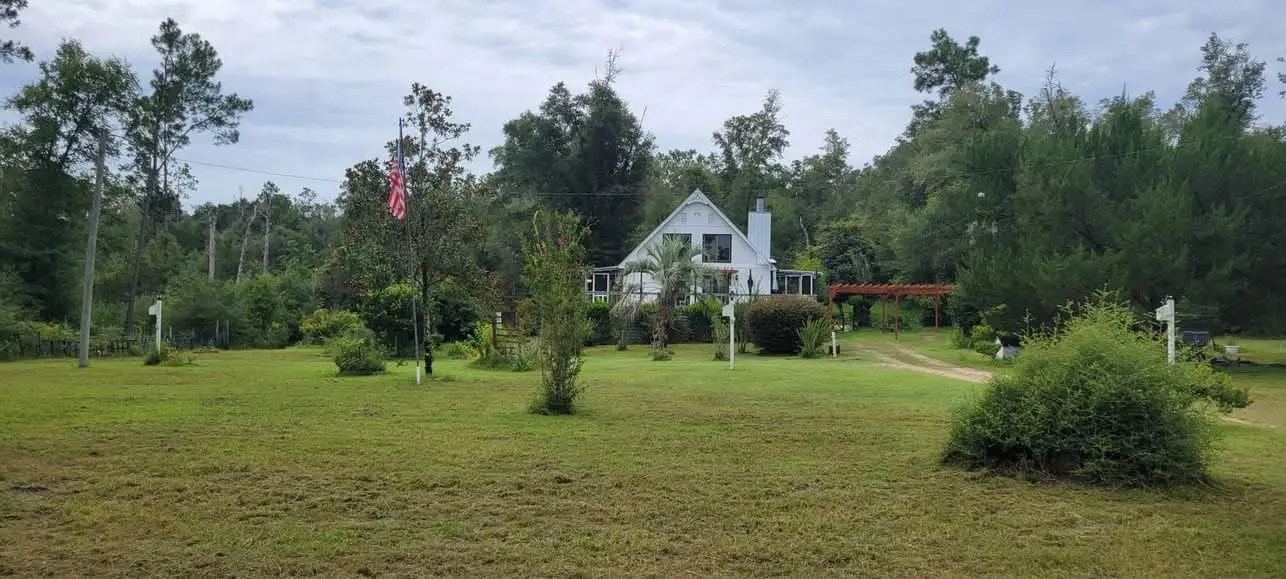 The same Panhandle acreage lot after Faith Lawn Care mowed it, cut clean around the farmhouse and back to the treeline